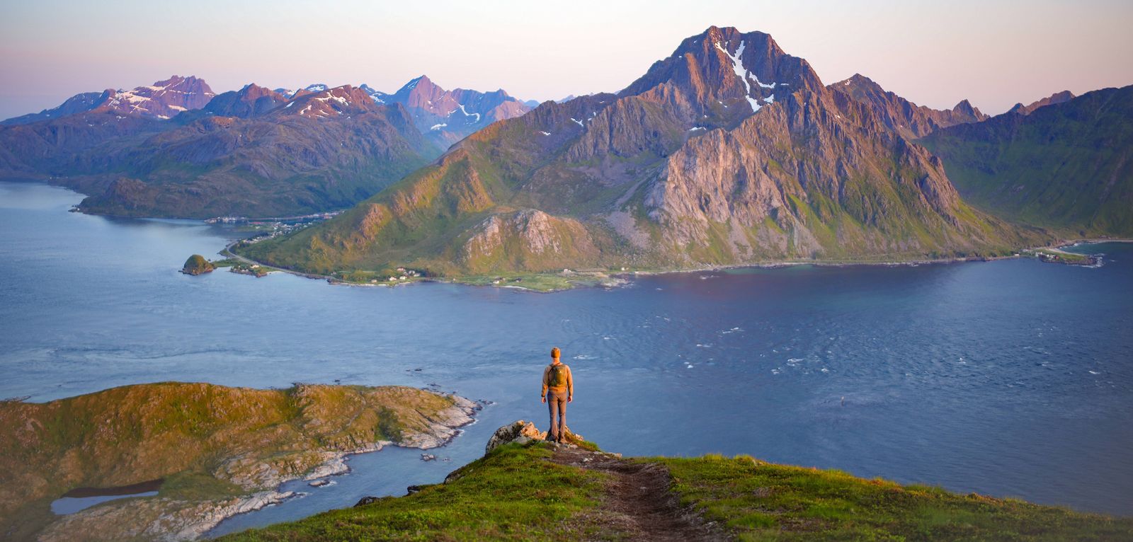 Alleinreisender auf dem Offersøykammen mit Blick über Fjorde und Berglandschaft der Lofoten in Norwegen