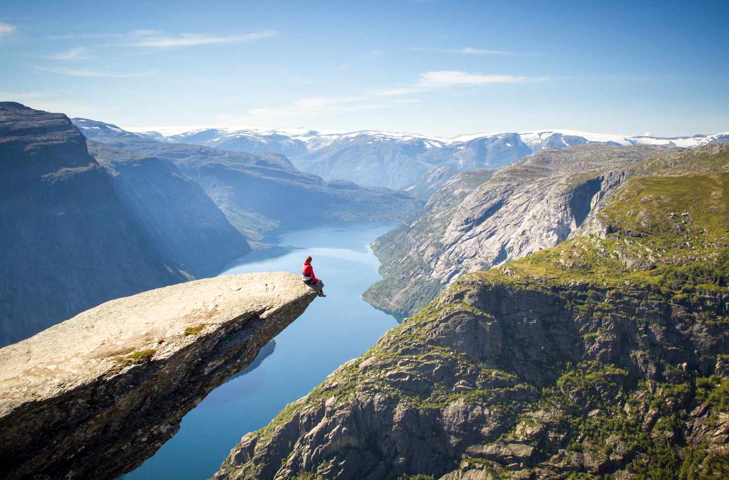 norwegen-wanderer-sitzt-auf-trolltunga-felsen-ueber-fjord-g-183930658.jpg