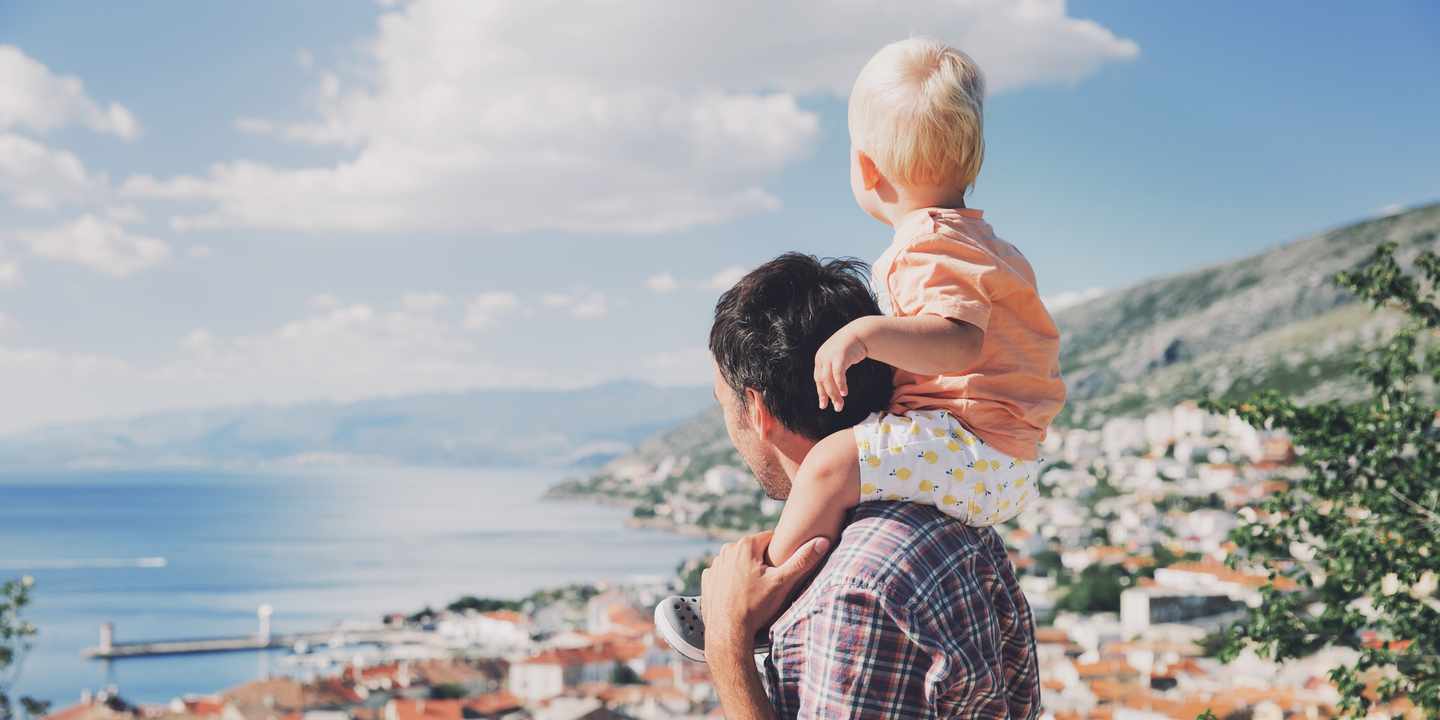 kroatien-vater_mit_kind_blicken_auf_eine_stadt-g-697946024.jpg