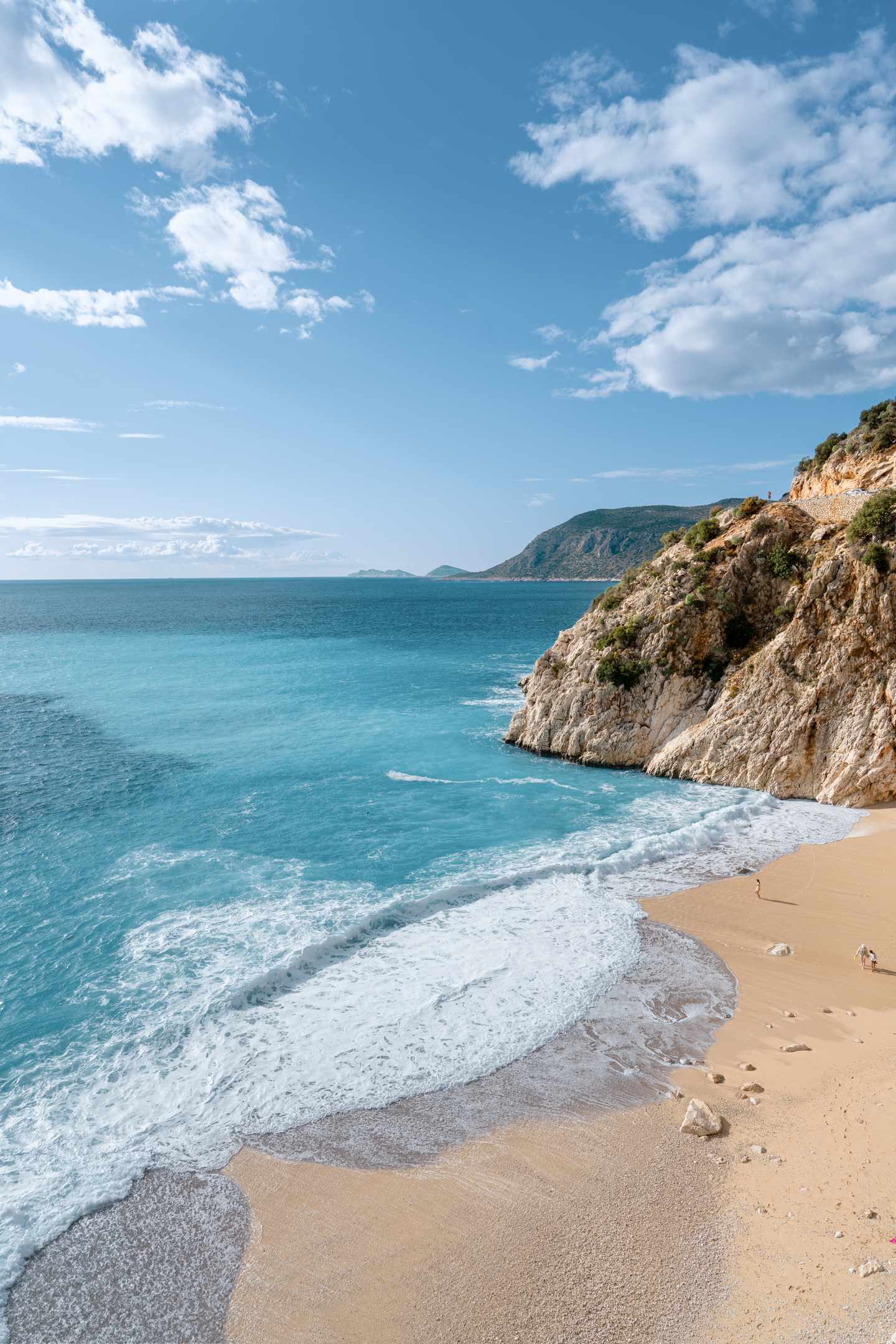 tuerkei-kaputas-weisser-sandstrand-klippen-g-1301917404.jpg Türkei Urlaub: Kaputas Strand mit türkisblauem Wasser und felsigen Klippen unter blauem Himmel.