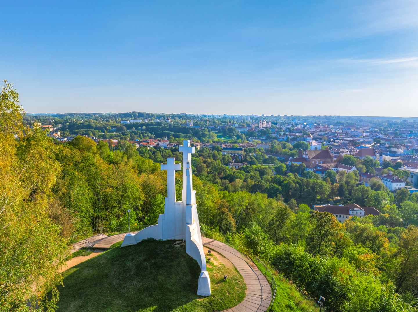 blta3de1402703ab2b5-litauen-vilnius-denkmal-der-3-kreuze-g-2182390966.jpg Drei weiße Stahlkreuze ragen auf einem bewaldeten Hügel in den Himmel