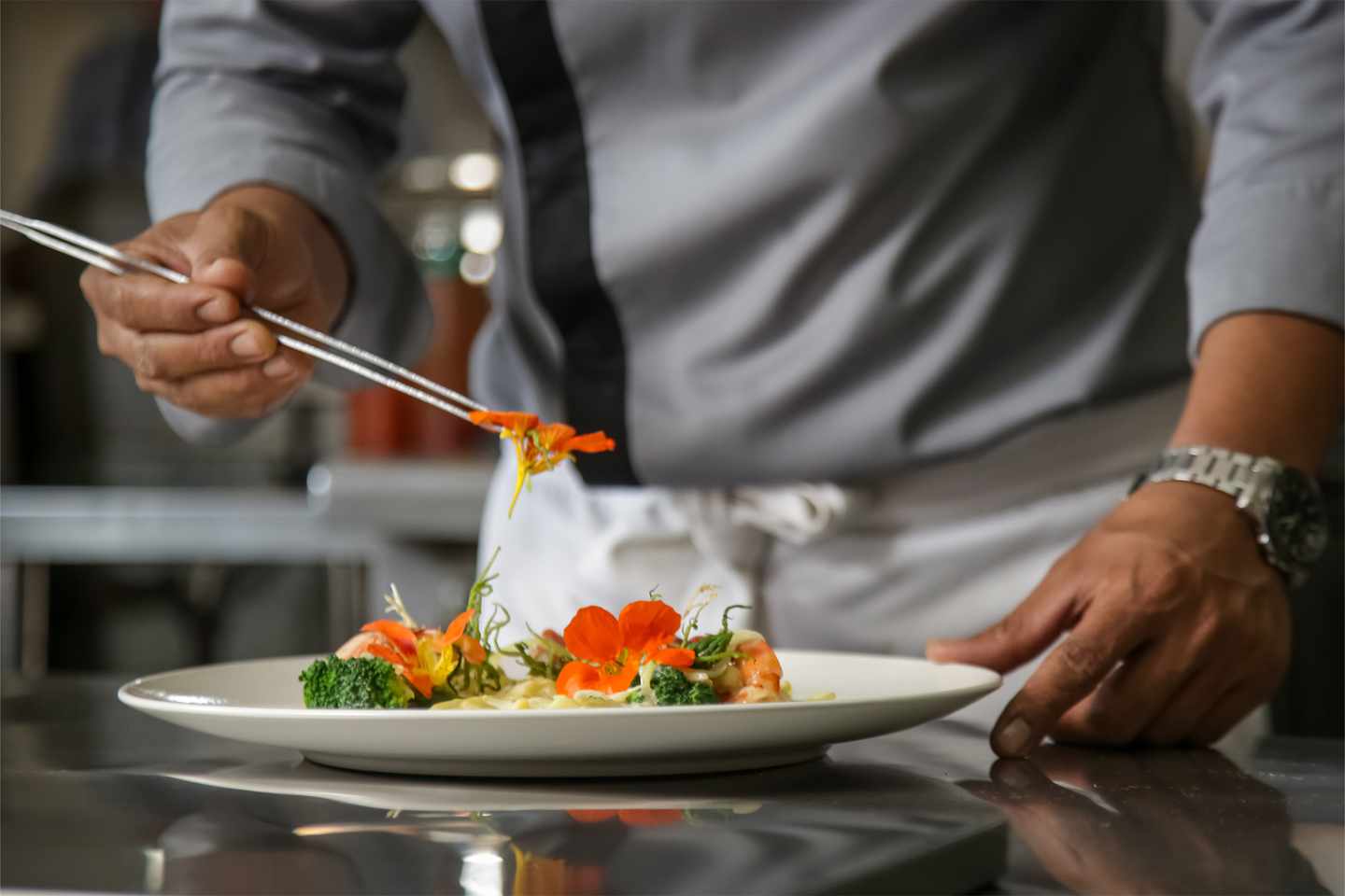 luxus-exklusive-restaurant-nahaufnahme-des-maennlichen-kuechenchefs-der-essbare-blumen-auf-dem-essen-in-der-kommerziellen-kueche-arrangiert-g-1171332236.jpg