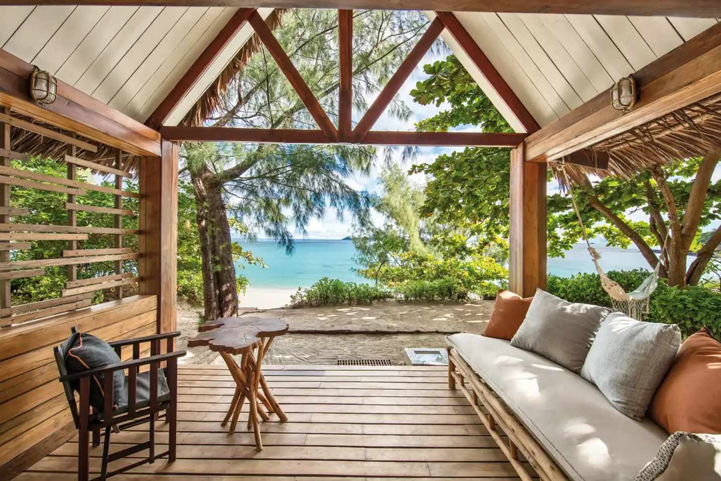 Offene Veranda eines Bungalows im Constance Tsarabanjina, Madagaskar, mit Sofa, Hängematte und Blick auf den Indischen Ozean