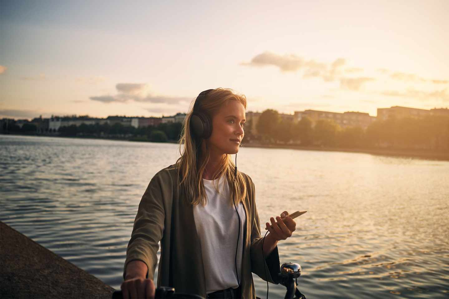 deutschland-bayern-schoenste-seen-frau-mit-fahrrad-am-wasser-hoert-musik-g-917742572.jpg