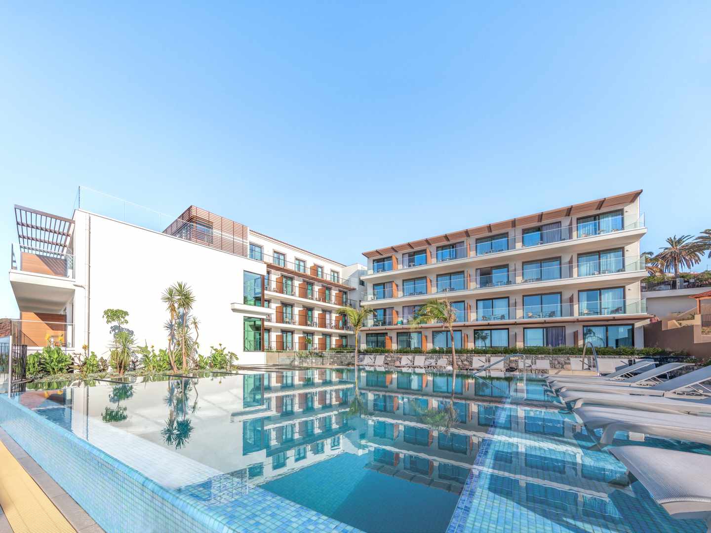 Außenpool des Sentido Galomar mit modernem Hotelgebäude und Sonnenliegen in Caniço auf Madeira