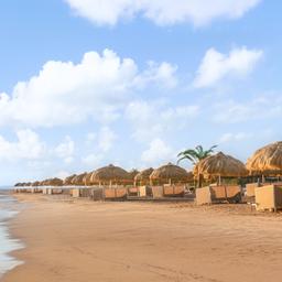 Breiter Sandstrand mit Strohschirmen und Liegen am Roten Meer in El Gouna, Ägypten