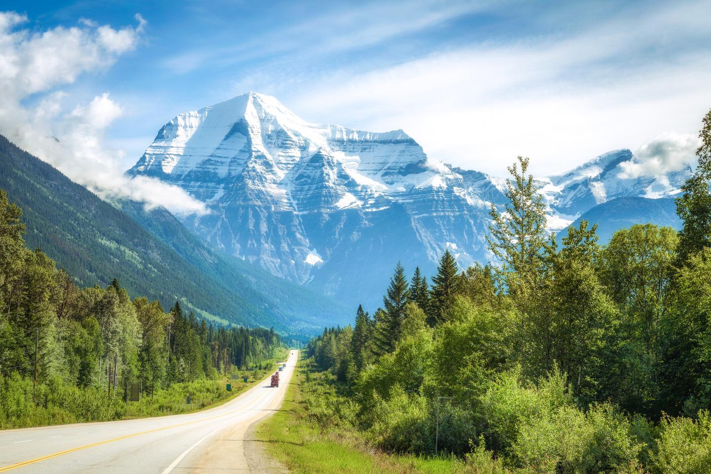 Straße des Yellowhead Highway vor dem schneebedeckten Mount Robson im Mount Robson Provincial Park in British Columbia