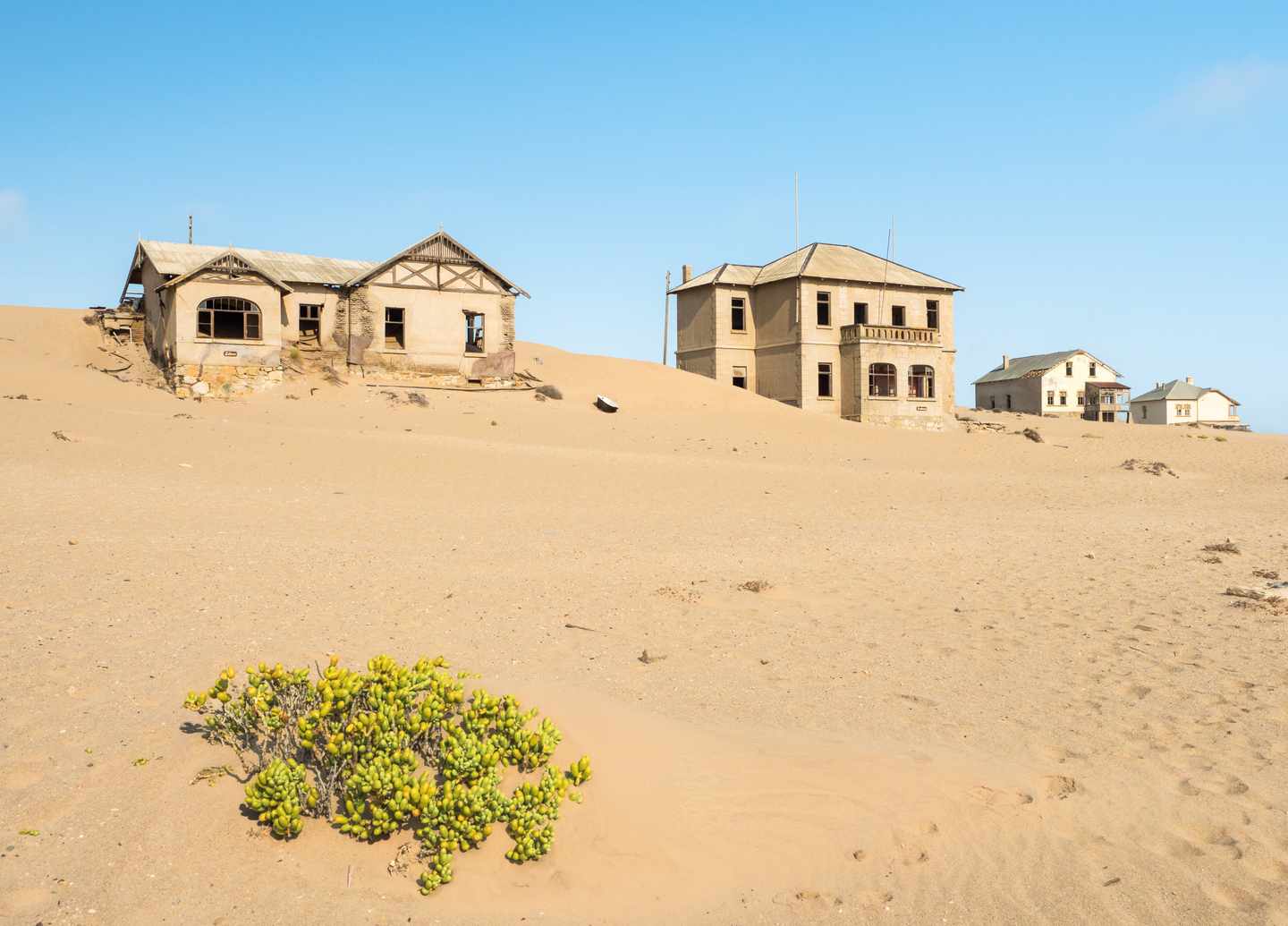 Verlassene Häuser der Geisterstadt Kolmanskop zwischen Sanddünen in der Namib-Wüste bei Lüderitz