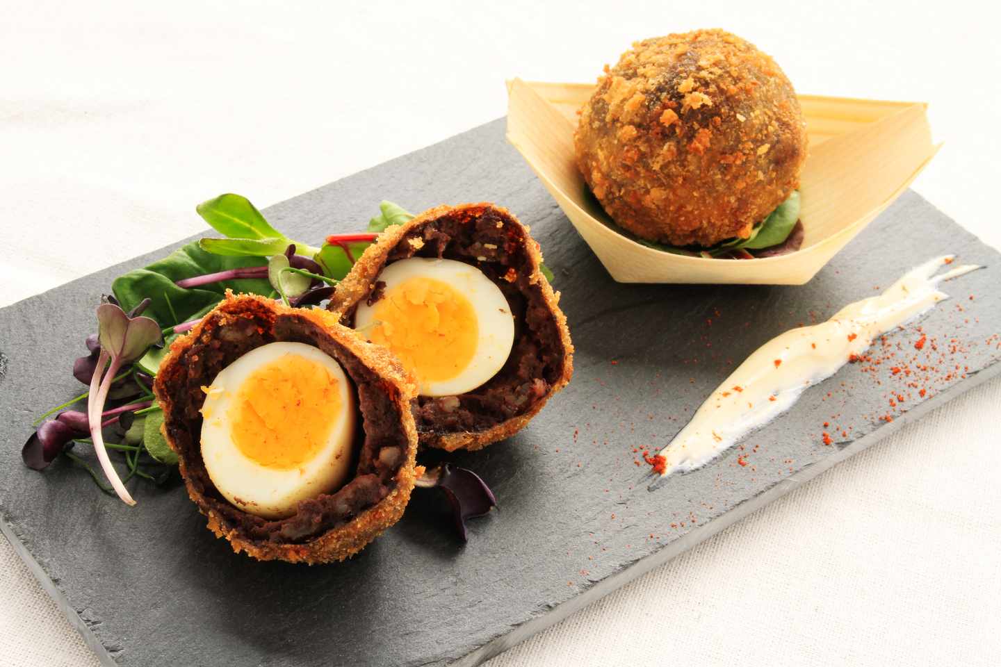 blt98aa18dba8e7f80a-grossbritannien-england-manchester-scotch-manchester-ei-in-black-pudding-g-493535963.jpg Gekochtes Ei umhüllt von britischem Black Pudding und Breadcrumps, eines aufgeschnitten und eines ganz