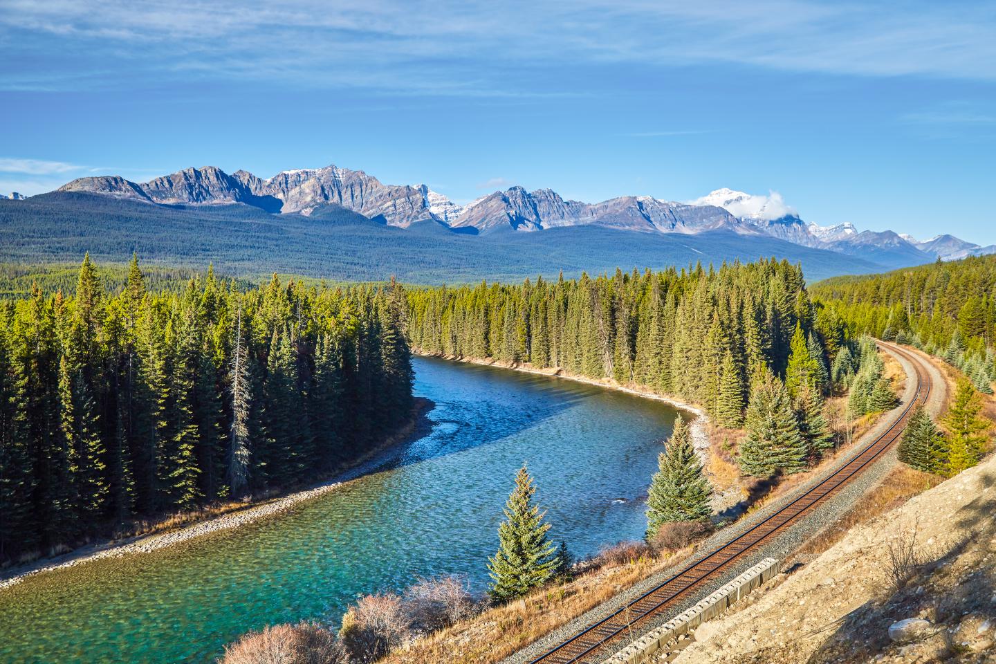 Blick auf die kanadischen Rocky Mountains mit dem Bow River und Schienen im Vordergrund