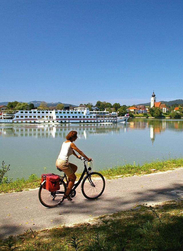 Radreisen Österreich - Radfahrer in Passau fährt entlang der Donau