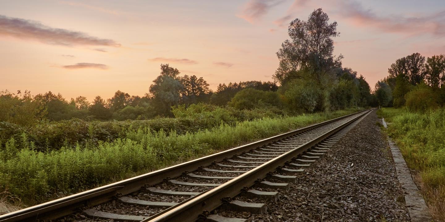 Bahnschienen in abendlicher Landschaft
