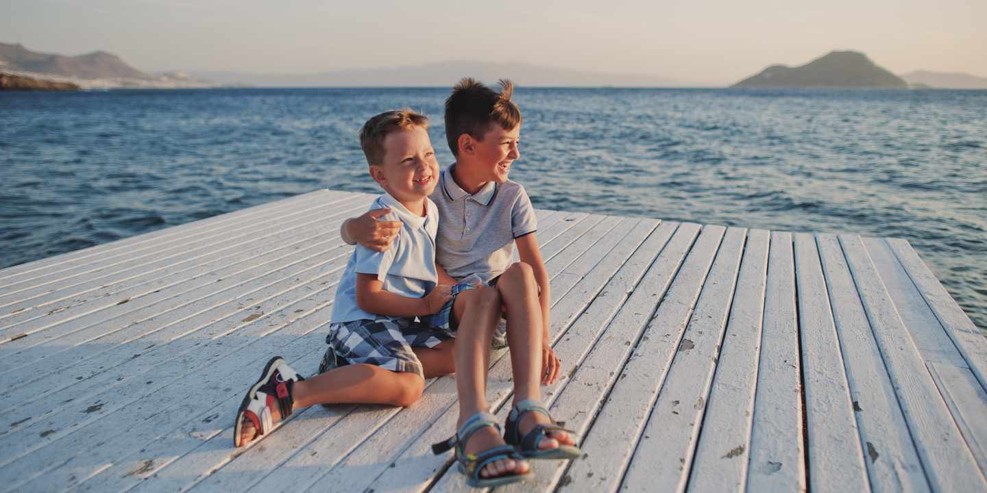tuerkei-familienurlaub-zwei-brueder-sitzen-am-pier-mit-mittelmeer-im-hintergrund-g-1358964959.jpg