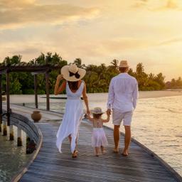 luxus-familienurlaub-eine-familie-geht-haendchenhaltend-ueber-einen-hoelzernen-pier-in-richtung-einer-tropischen-insel-g-1352015722.jpg