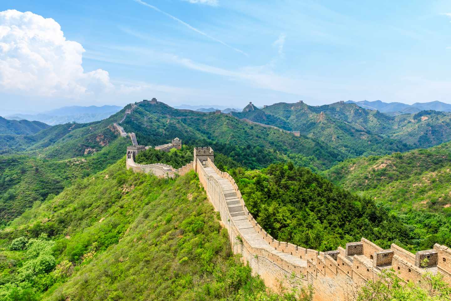 Chinesische Mauer mit Wachtürmen auf bewaldeten Bergrücken bei Jinshanling in China