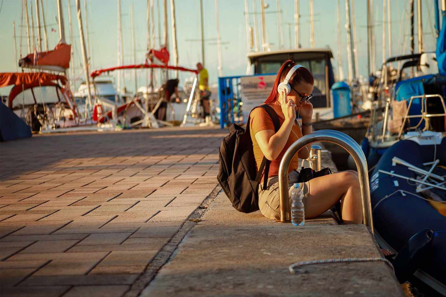 deutschland-nordsee-tagesausflug-frau-sitzt-im-hafen-am-rand-und-hoert-musik-g-1353250171.jpg