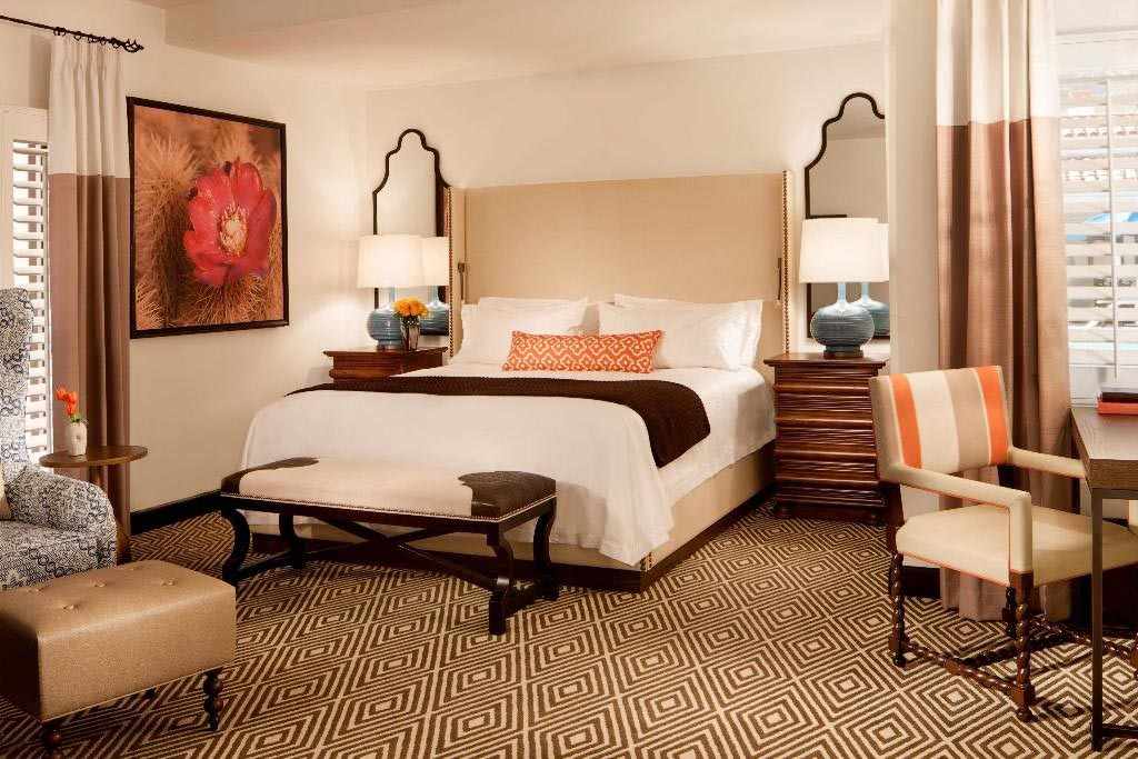 Ein Zimmer im Coachella-Hotel La Quinta Resort & Club, Curio Collection by Hilton mit gemütlichem Bett, Sessel und Sitzbereich