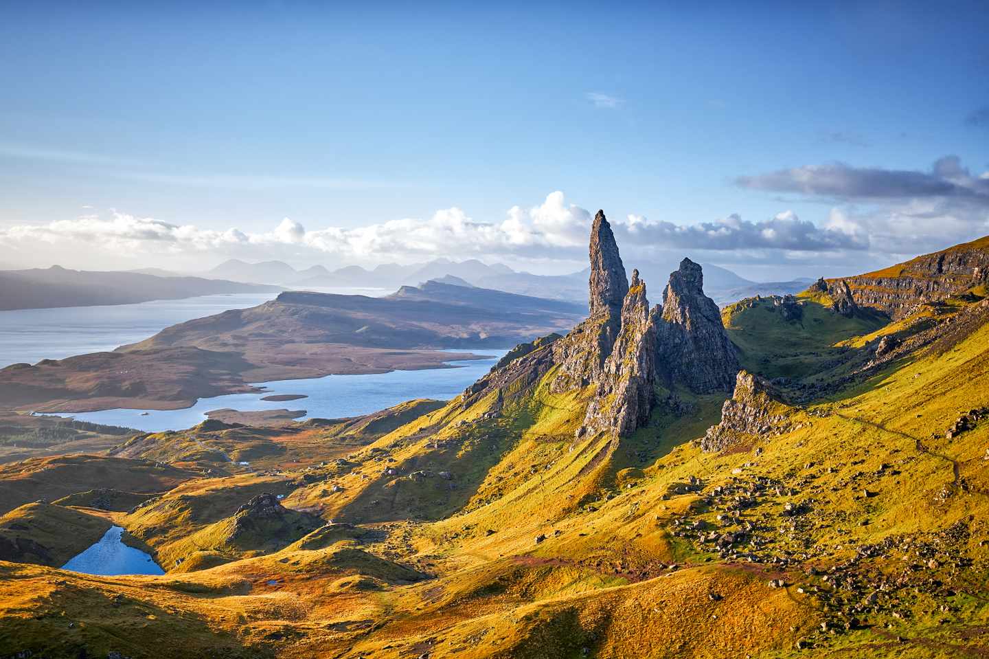 Felsnadel Old Man of Storr über Hügellandschaft mit Seen auf der Isle of Skye in Schottland