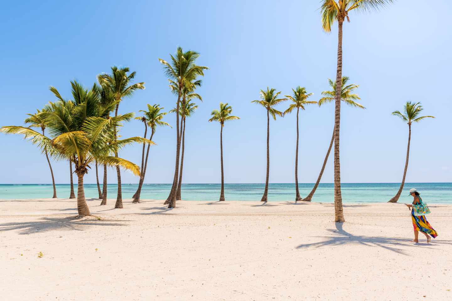 GettyImages-857744014.jpg Tourist läuft am Strand in der dominikanischen Republik an Palmen vorbei.