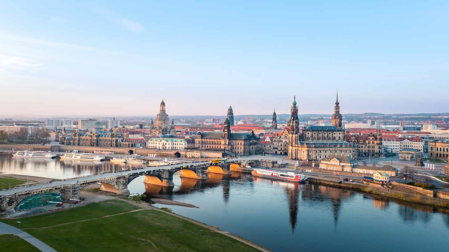 Blick über die Elbe und Augustusbrücke auf die historische Altstadt von Dresden mit Frauenkirche und Hofkirche