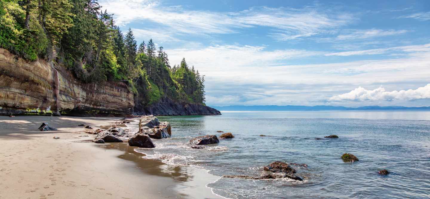 Mystic Beach mit Sandstrand, Felsen und bewaldeter Steilküste am Pazifik auf Vancouver Island in British Columbia