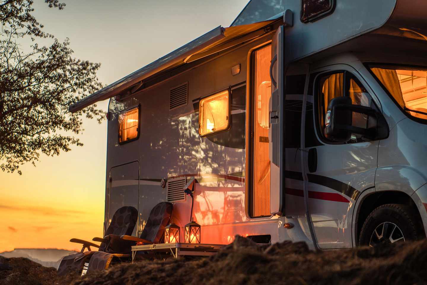 usa-camper-im-sonnenuntergang-mit-stuehlen-und-kerzen-g-1180416905.jpg
