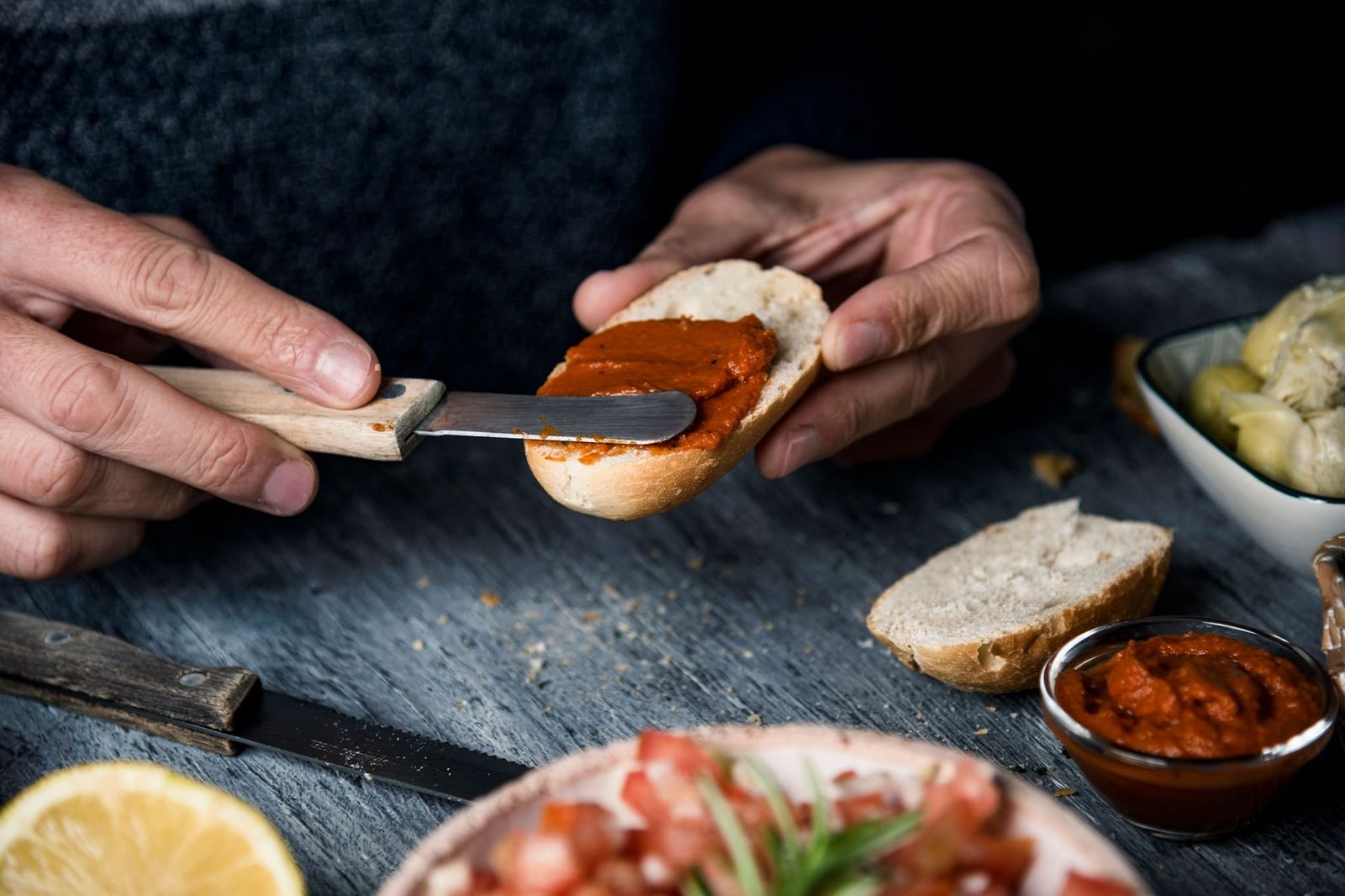 Mann schmiert ein Brot mit Sobrasada
