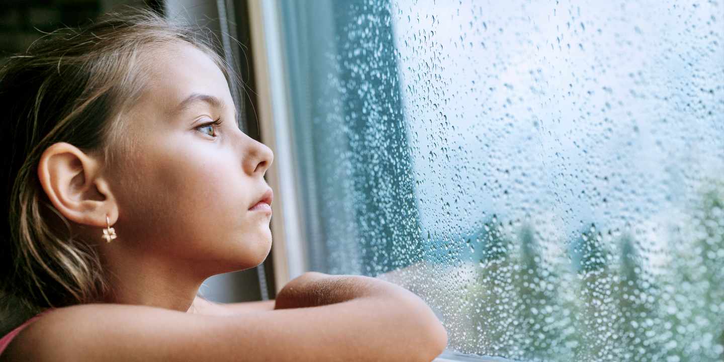 familienurlaub-kind-sitzt-traurig-vor-dem-vollgeregneten-fenster-g-1170879567.jpeg