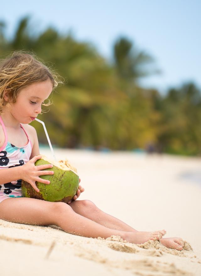 Familienurlaub Mauritius mauritius-kleines-maedchen-trinkt-am-strand-aus-einer-kokosnuss-g-1358019179.jpg