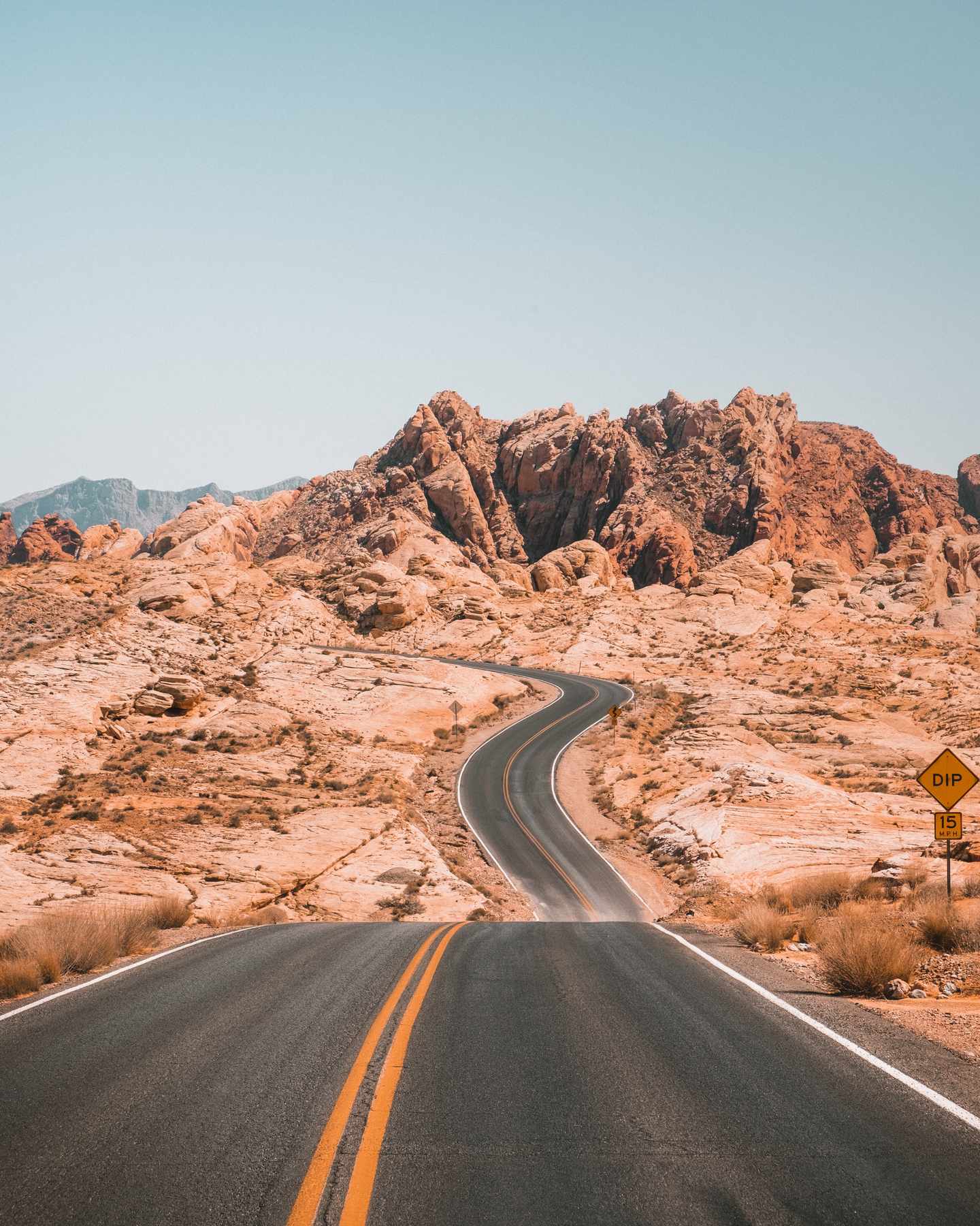 GettyImages-1128513862.jpg Lange kurvenreiche Straße mit Felsformation im Hintergrund im Valley of Fire Nevada