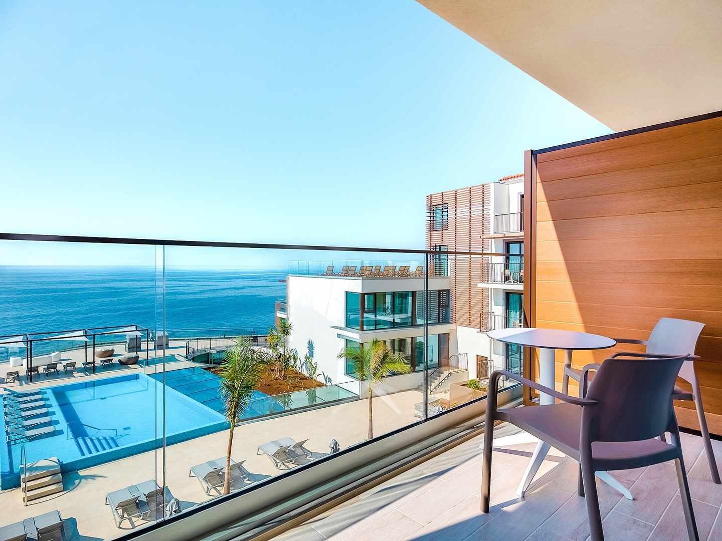blt7441a48c2f21c670-portugal-madeira-canico-zimmer-balkonblick-pool-meer-h-sentido-galomar-DER0950489.jpg Blick vom Balkon mit Sitzgelegenheit auf Pool und Meer