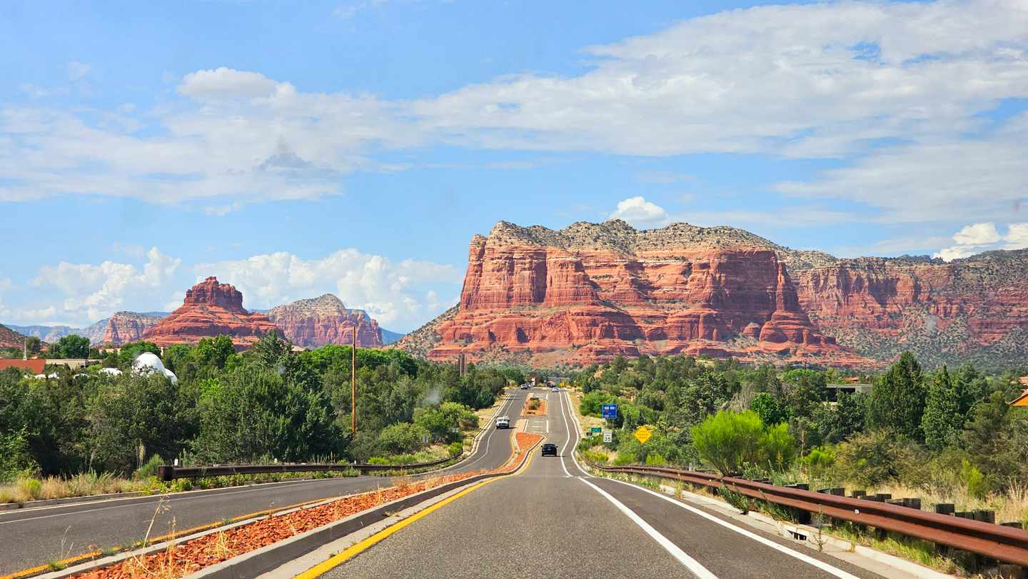 Straße durch Sedona in Arizona mit markanten roten Sandsteinfelsen und grüner Vegetation