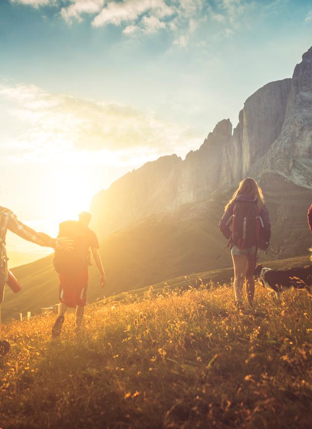 Reisekalender September. Wanderer in Südtirol. Sonne strahlt über einem Berg