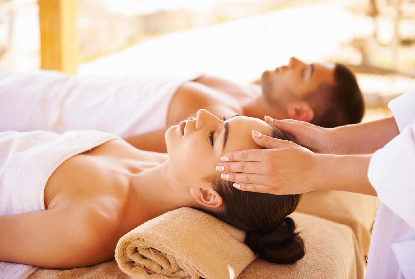 Ein Paar genießt während eines Wellnessurlaubs eine entspannende Kopfmassage im Spa-Bereich