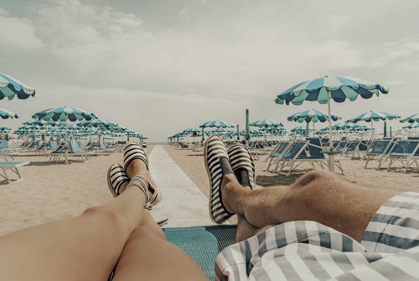italien-emilia-romagna-rimini-paar-strand-schirme-liegestuehle-g-974719424.jpg