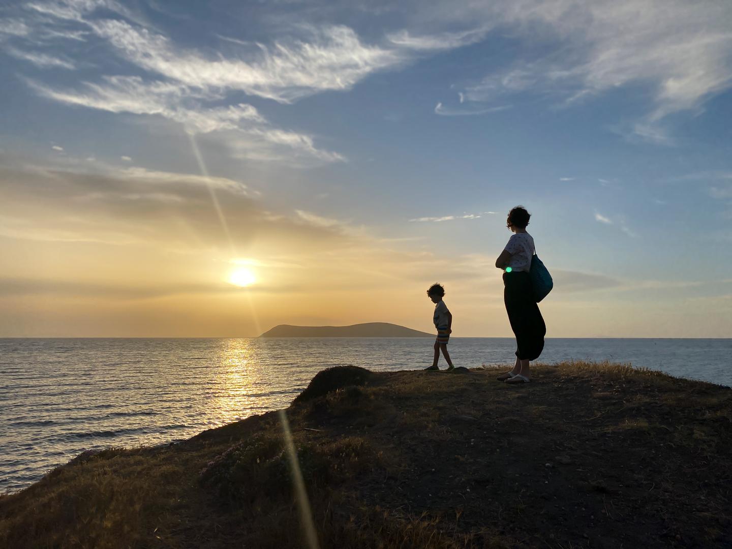 Mutter und Sohn bei Sonnenuntergang am Meer in Gümuslük
