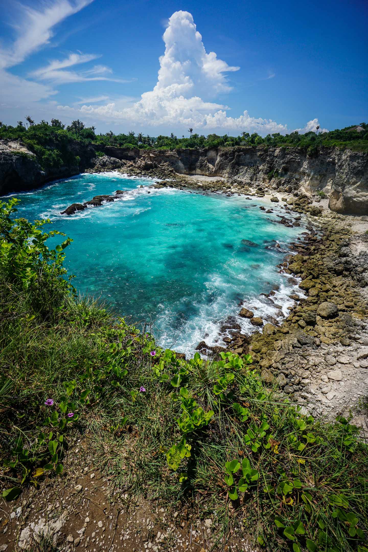 GettyImages-2291896607.jpg Blue Lagoon Cove mit türkisfarbenem Wasser felsigem Ufer und dramatischen weißen Cumuluswolken auf Bali