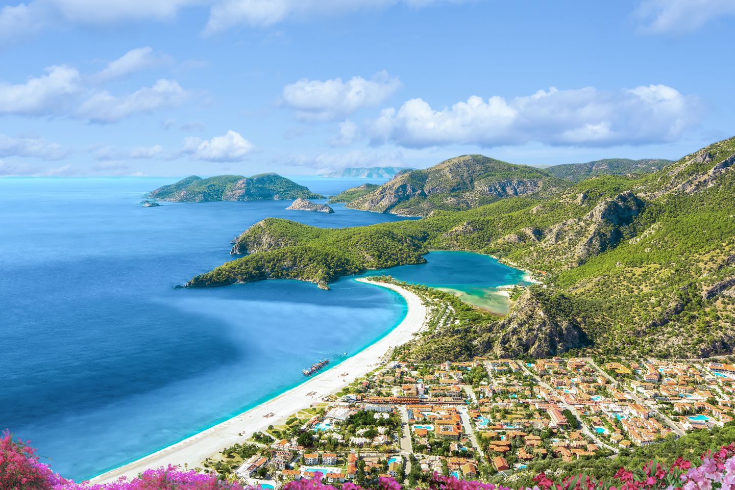 Türkei Urlaub: Luftaufnahme der Blauen Lagune von Ölüdeniz mit türkisblauem Wasser und grünen Hügeln.
