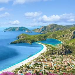 Türkei Urlaub: Luftaufnahme der Blauen Lagune von Ölüdeniz mit türkisblauem Wasser und grünen Hügeln.