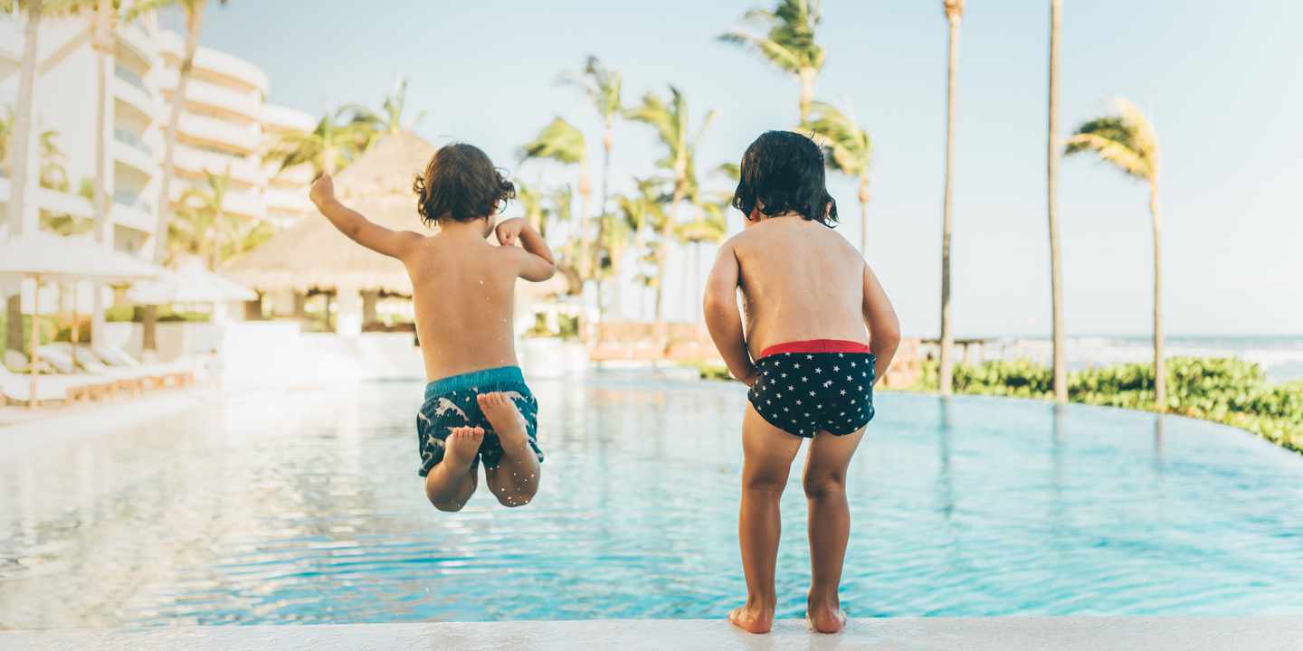 mexiko-mit-kindern-zwei-kinder-springen-in-den-pool-g-1126429017.jpg