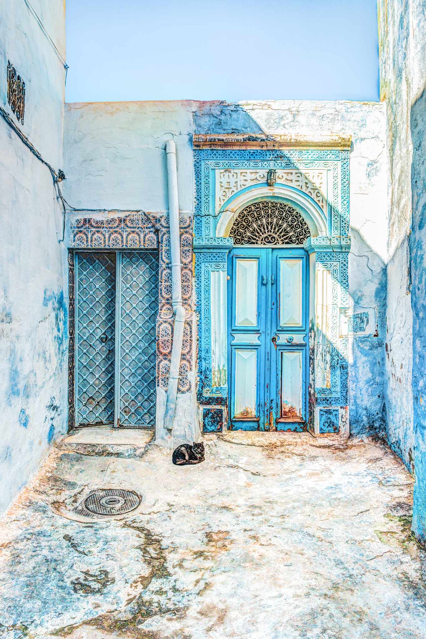 GettyImages-700443604.jpg Verzierte blaue Tür in der Medina Tunesiens mit traditionellen Fliesen und weißer Fassade