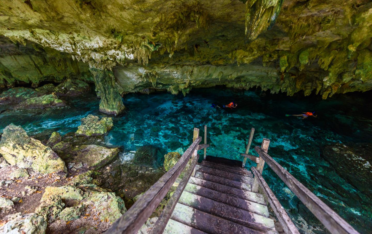 Menschen schwimmen und schnorcheln in der Cenote Dos Ojos in Quintana Roo, Mexiko