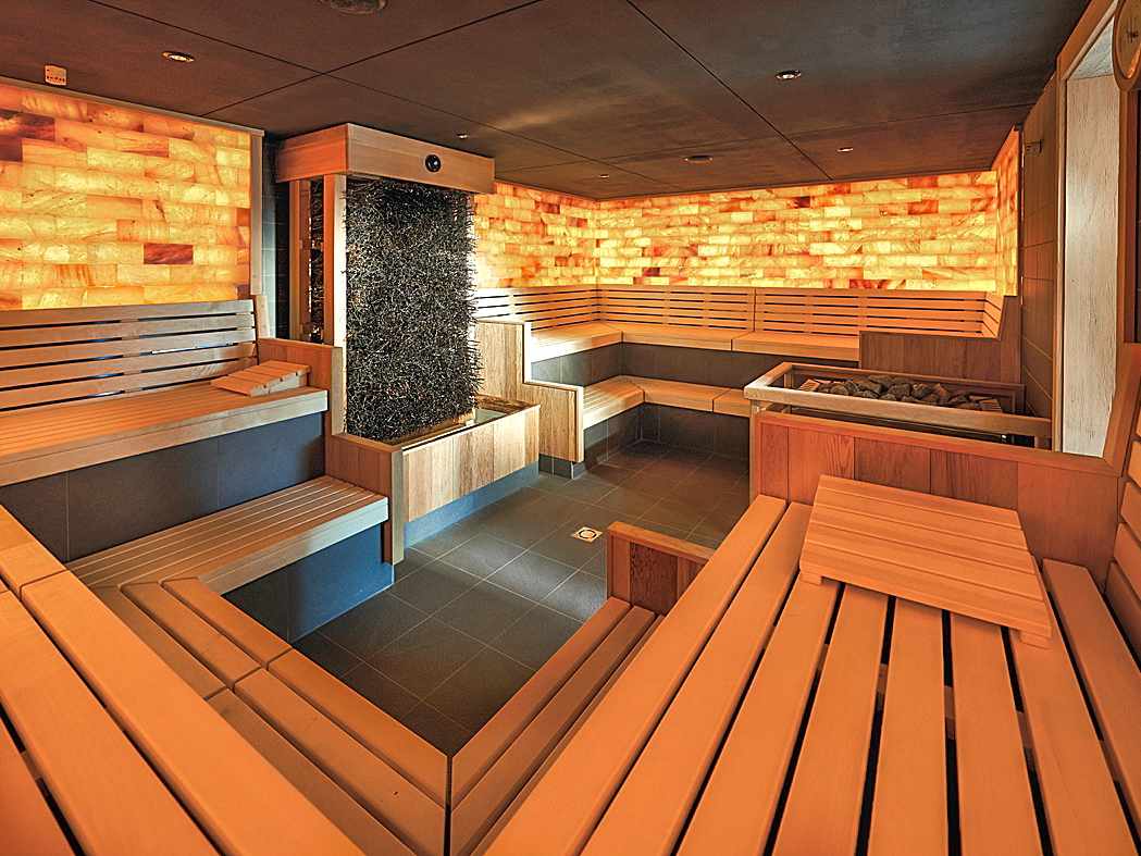 bltaa20f35562dd968a-deutschland-radolfzell-bodensee-bora-hotsparesort-sauna-salzsteinwand-wellnesshotel-DER1069030.jpg Saunabereich im bora HotSpaResort Radolfzell mit Holzliegen und beleuchteter Salzsteinwand
