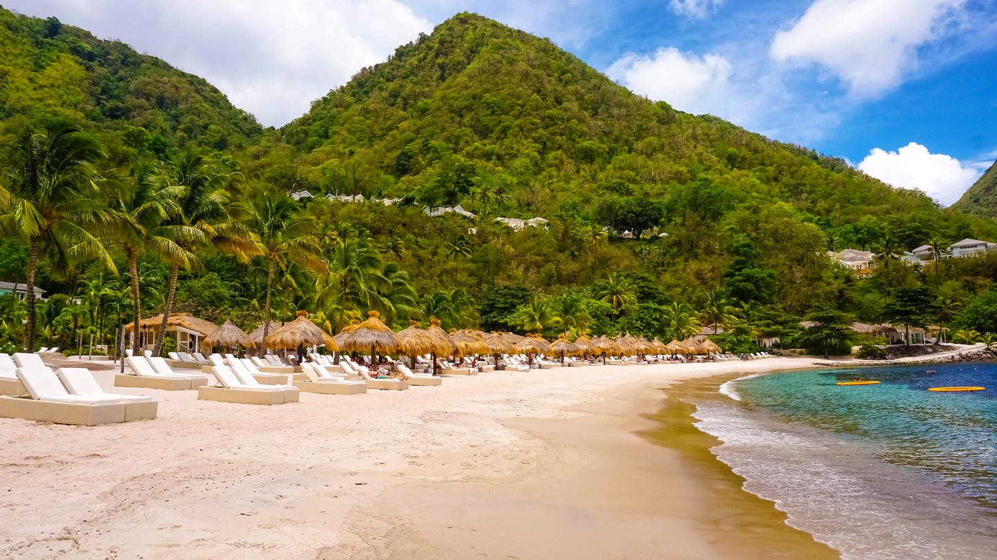 Aussicht auf einen Strand in Saint Lucia mit grünen Bergen im Hintergrund