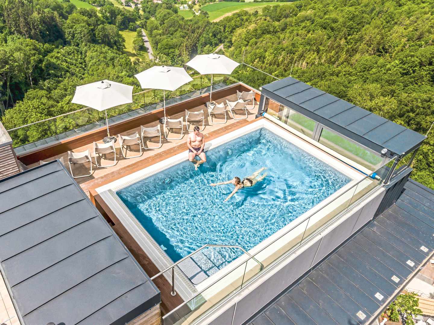 bltc52d5d1615088ee9-deutschland-baden-wuerttemberg-langenburg-mawell-resort-dachpool-wald-panorama-wellnesshotel-DER1442011-3.jpg Dachpool im Mawell Resort Langenburg mit Liegen und Blick über die bewaldete Hügellandschaft