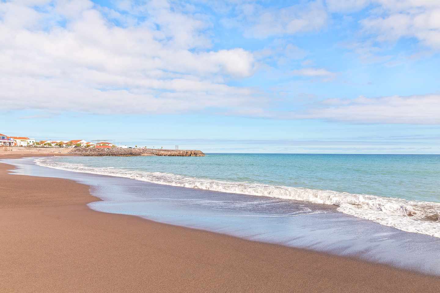 Schwarzer Sandstrand Praia do Fogo in Ribeira Quente auf São Miguel mit sanften Atlantikwellen