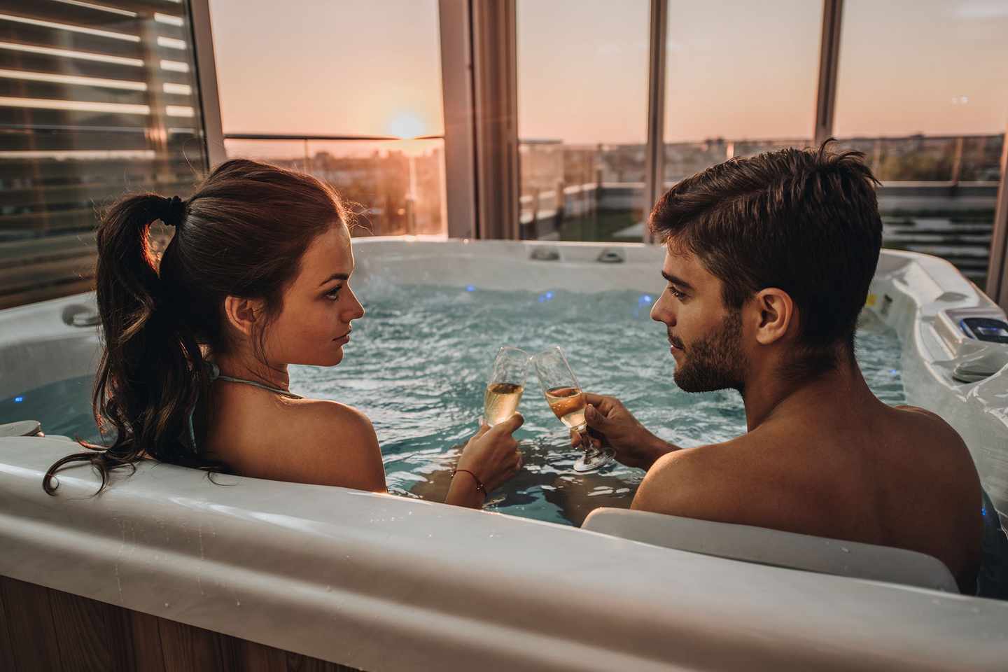 luxus-luxus-wellness-anwendungen-paerchen-im-whirlpool-stossen-mit-champagner-an-g-911941296.jpg