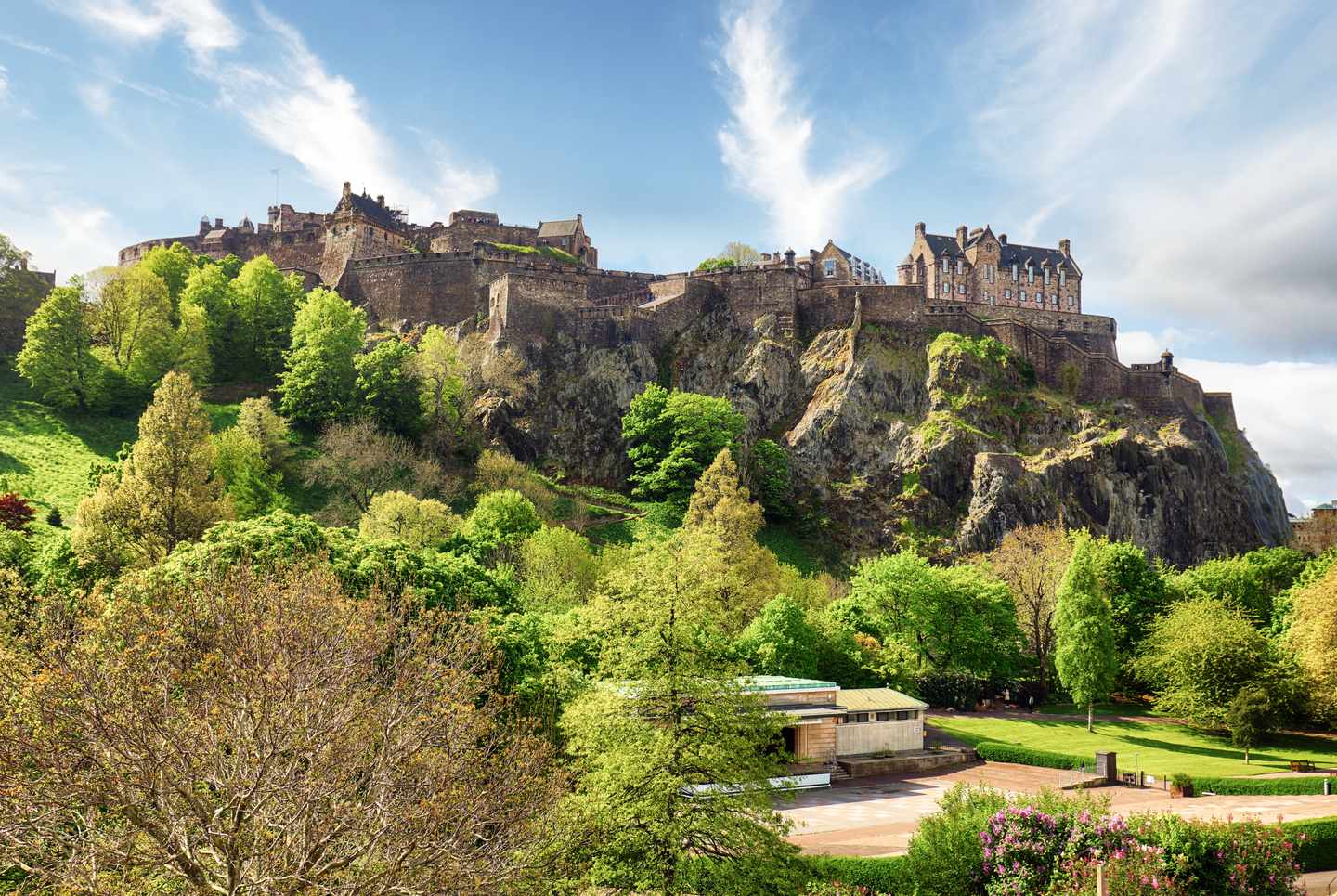 Edinburgh Castle erhebt sich über der dicht bebauten Altstadt und der schottischen Flagge auf einem Turm