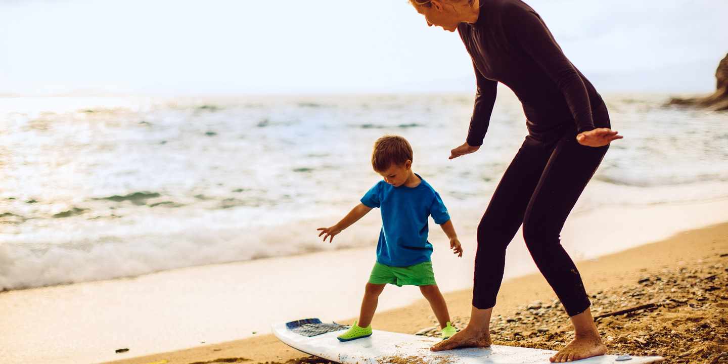kind-und-frau-auf-surfbrett-am-strand-g-488319092.jpg