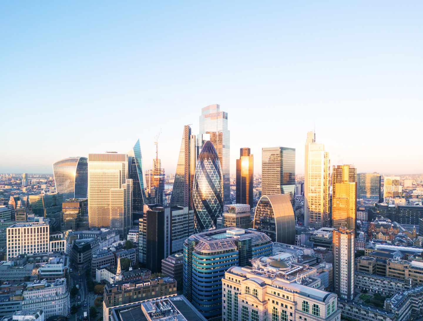 Moderne Hochhäuser der City of London mit markanter Skyline im warmen Licht über dem Stadtzentrum